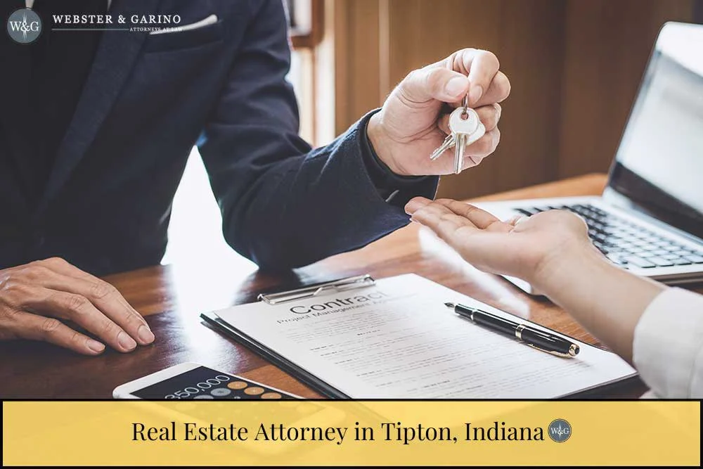 real estate attorney in Tipton, Indiana handing keys to people after signing contract.