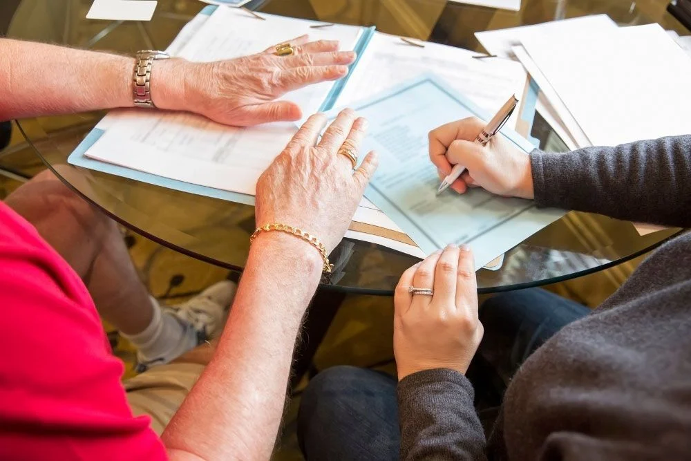 Family reviewing estate planning documents and signing forms with Webster & Garino attorney guidance.
