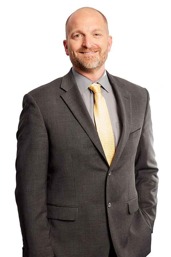 A man in a suit smiles confidently, representing a trusted Indiana law firm offering compassionate legal guidance.| Webster & Garino, LLC | Indiana Law Firm serving Hamilton County